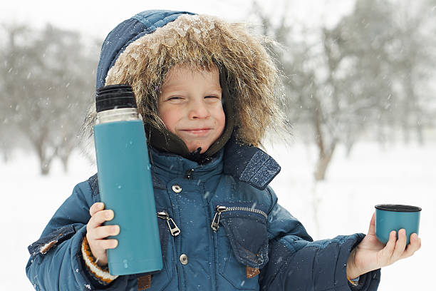 istock Funny small boy invites to drink hot tea from thermos 167180266