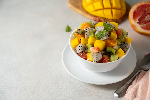 Exotic fruit salad with fresh mango, dragon fruit, grapefruit, kiwi.