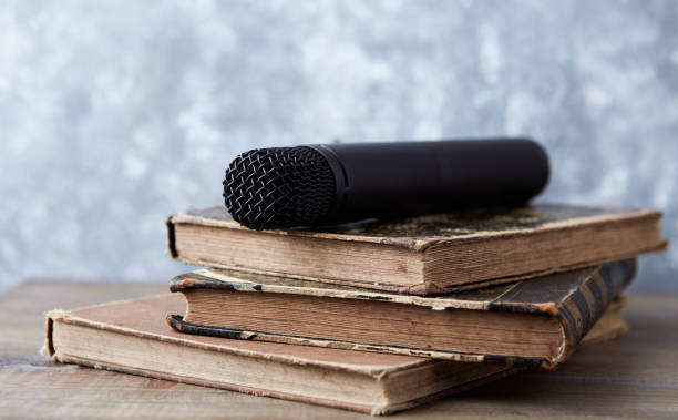 istock Modern microphone lying on old books. Close up. Copy space. 1671806667