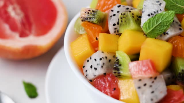 Exotic fruit salad with fresh mango, dragon fruit, grapefruit, kiwi.