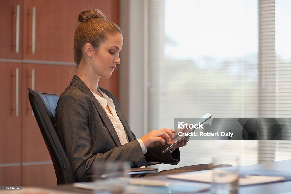 Sonriente mujer de negocios con tableta en escritorio de oficina - Foto de stock de 20-24 años libre de derechos