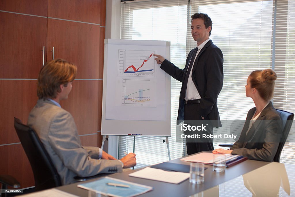 Бизнесмен показывает на флипчарте в конференц-зале - Стоковые фото 20-24 года роялти-фри
