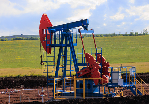 oil pump in a field pumps oil out of the ground