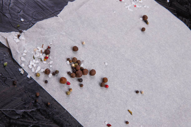 Salt and pepper peas on a black stone board and parchment paper, macro