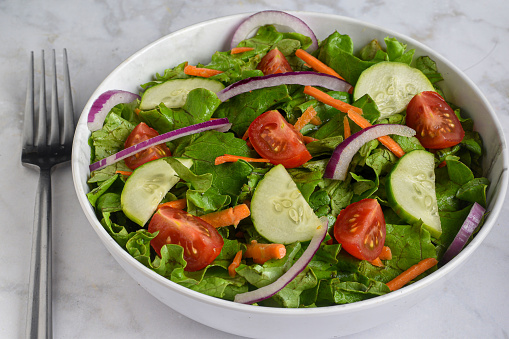 garden salad with onions, tomatoes,  and carrots