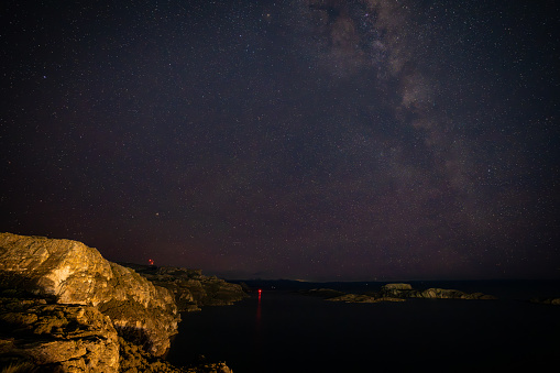 Lone person stargazing by the ocean in Cabo San Lucas