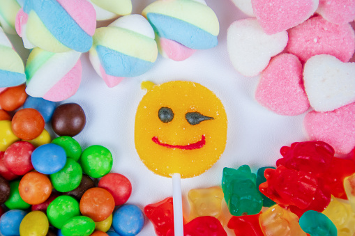 piles of various kinds of sweets and candies with a focus on the smiling candy