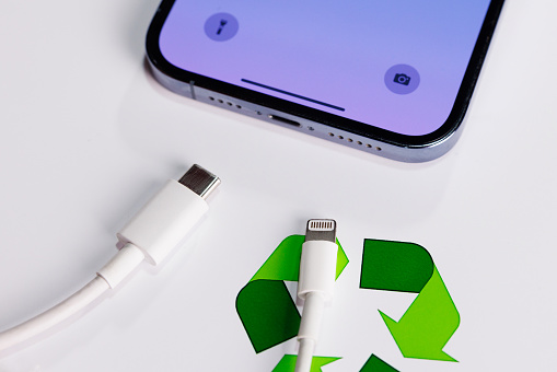 View of Apple Iphone with Both Usb-c and Lightning Cable Charger. EU Forced Apple Iphone to Use Usb-c Instead of Lighting Cable in 2024. Concept of recycle Lightning cable charger.