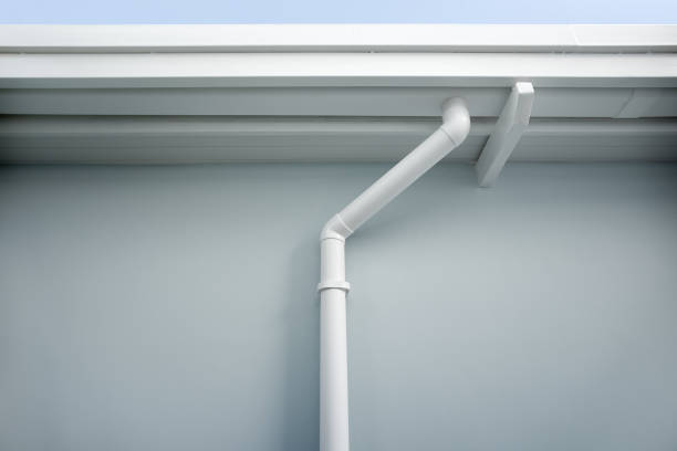 Rain gutter connect to downspout for water drainage system. Rain gutter install on steel structure, connect to pvc downpipe or downspout, elbow at eaves, exterior house building. Also called guttering or eavestrough for water drainage system. Look new clean. eaves stock pictures, royalty-free photos & images