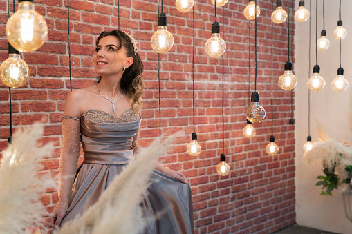 The new bride dances happily among the light bulbs. Young woman looking radiant among the glow of electric lights.