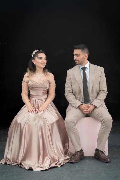 The young couple is celebrating their engagement. The man wore a suit and the young woman wore a long dress. very happy young couple posing for camera and having fun.