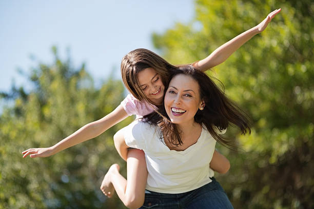 istock Playful Mother Piggybacking Daughter In Park 167201678