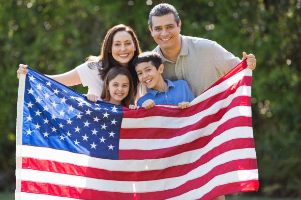 istock Family Smiling While Holding American Flag At Park 167201710