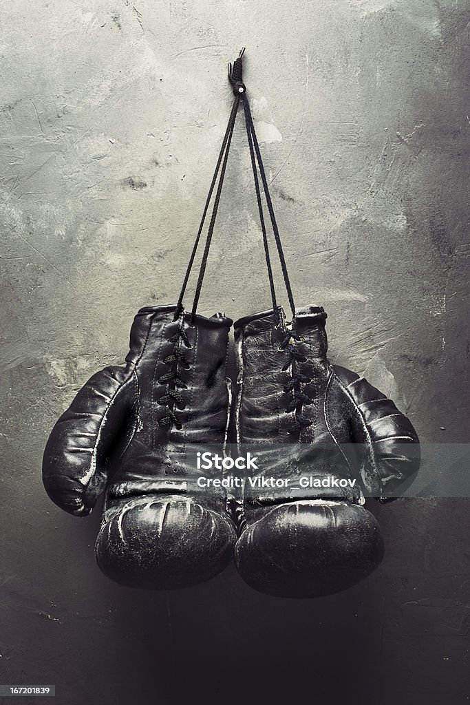 old boxing gloves hang on nail old boxing gloves hang on nail on texturе wall. Retirement concept Boxing - Sport Stock Photo