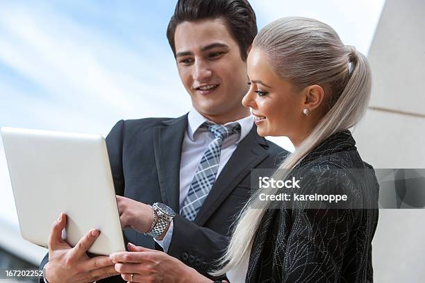 Business Partners Reviewing Information On Laptop Stock Photo - Download Image Now - Adult, Business, Business Meeting