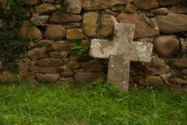 istock Stone Cross over an ancient stone wall 1672042702