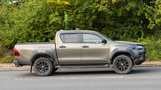 Milton Keynes,UK-Sept 10th 2023: 2022 bronze Toyota Hilux truck travelling on an English road.