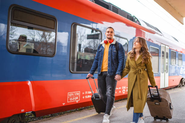 istock Couple with suitcases leaving the train station 1672074806