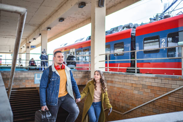 istock Couple with suitcases arriving on the train station 1672074865