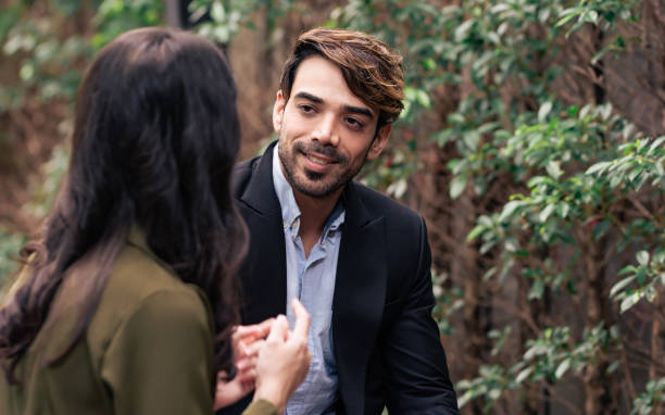 istock Selective focus Caucasian smart handsome businessman smiling with happiness, flirting, sitting and talking with female colleague at outdoor park of office. 1672081825