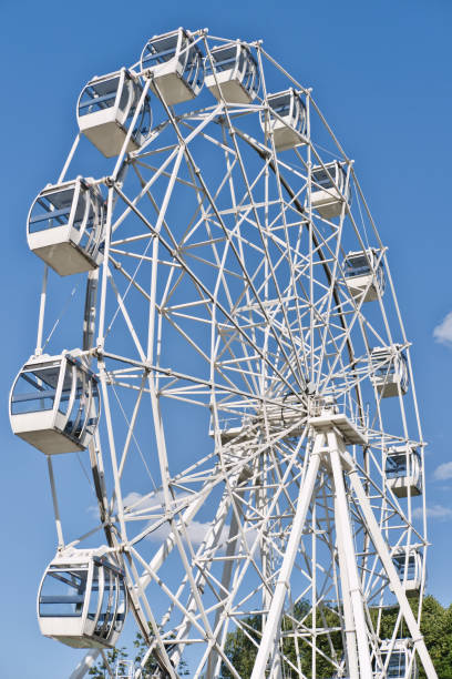 istock Modern ferris wheel in an amusement park against blue sky with clouds. 1672086533
