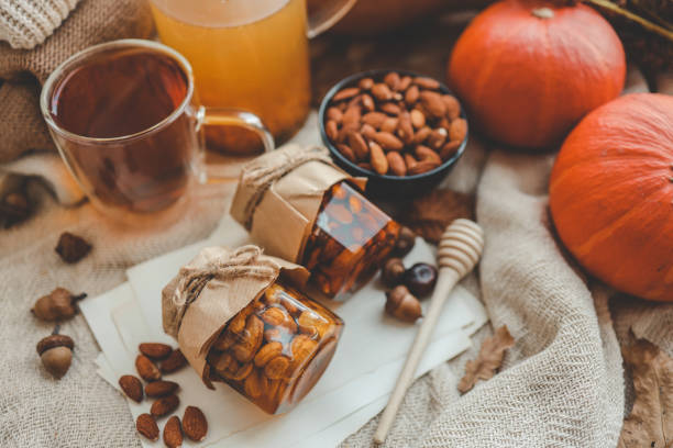 Jars with craft sweet honey and nuts in autumn interior