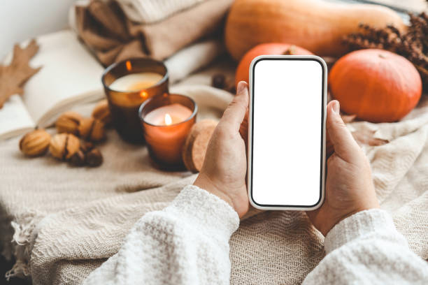 istock Phone with an isolated screen in hands, autumn mood 1672091770