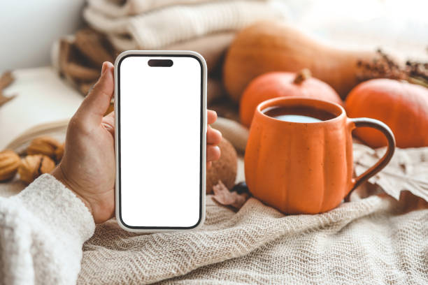 istock Phone with an isolated screen in hands, autumn mood 1672091778
