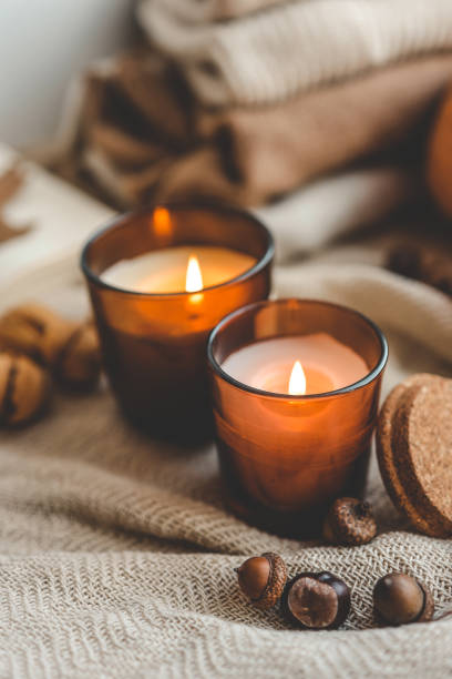 istock Two burning candles in the autumn interior 1672093341