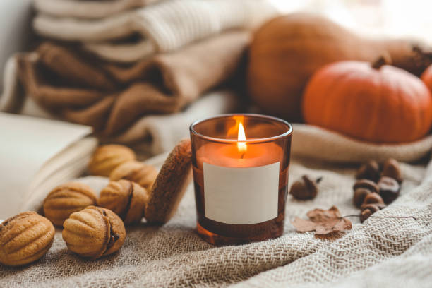 istock Burning candle with label isolated in autumn interior 1672093343