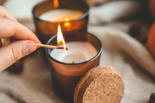 istock Match in hand lights a candle, cosiness concept 1672093364