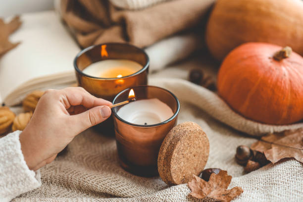 istock Match in hand lights a candle, cosiness concept 1672093575