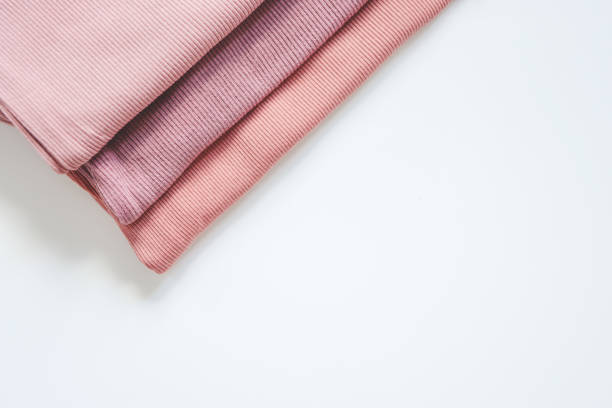 istock Stack of pink baby clothes on white background 1672103116