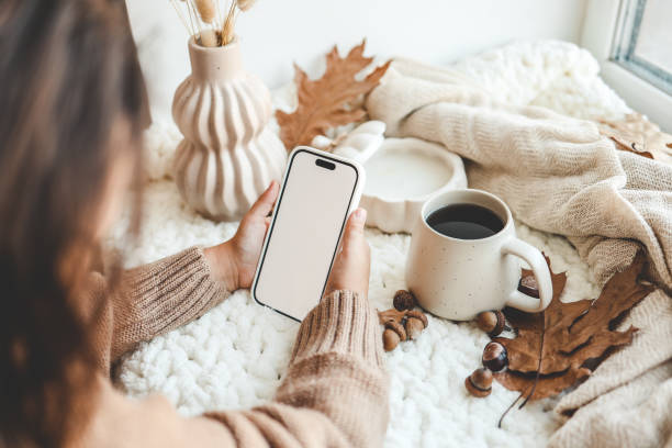 istock Phone with an isolated screen in hands, autumn mood 1672106795