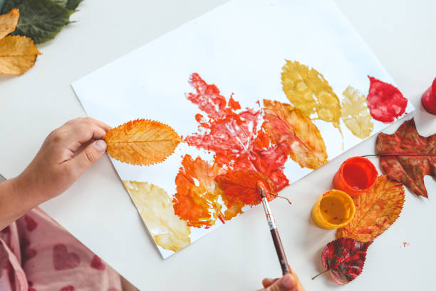 istock Children's autumn activity, leaf print on paper 1672107363