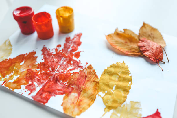 istock Children's autumn activity, leaf print on paper 1672107367