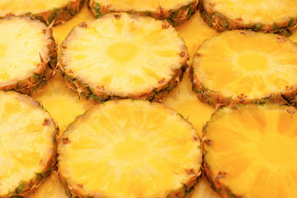 Pineapple juicy yellow slices as a background. Top view.