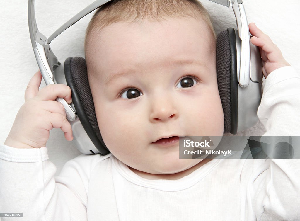 Bebé escuchando música en la parte posterior - Foto de stock de Acostado de espalda libre de derechos