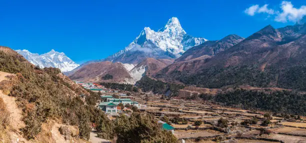 Ama Dablam’s jagged peaks soaring over the Sherpa farms in Dingboche overlooked by Lhotse and Mt. Everest high in the Himalayan mountains of Nepal.