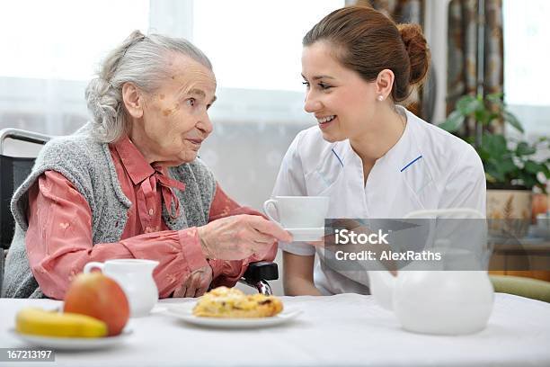 Carer In Nursing Home Handing An Elderly Woman A Cup Of Tea Stock Photo - Download Image Now