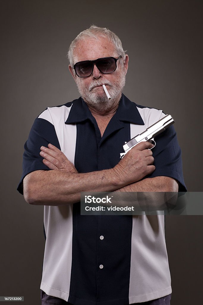 Man smoking a cigarette and holding handgun Senior man smoking a cigarette and holding a handgun 60-69 Years Stock Photo