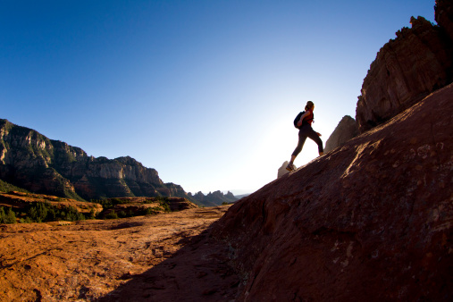 A woman hikes a popular trail in Sedona, Arizona, USA.