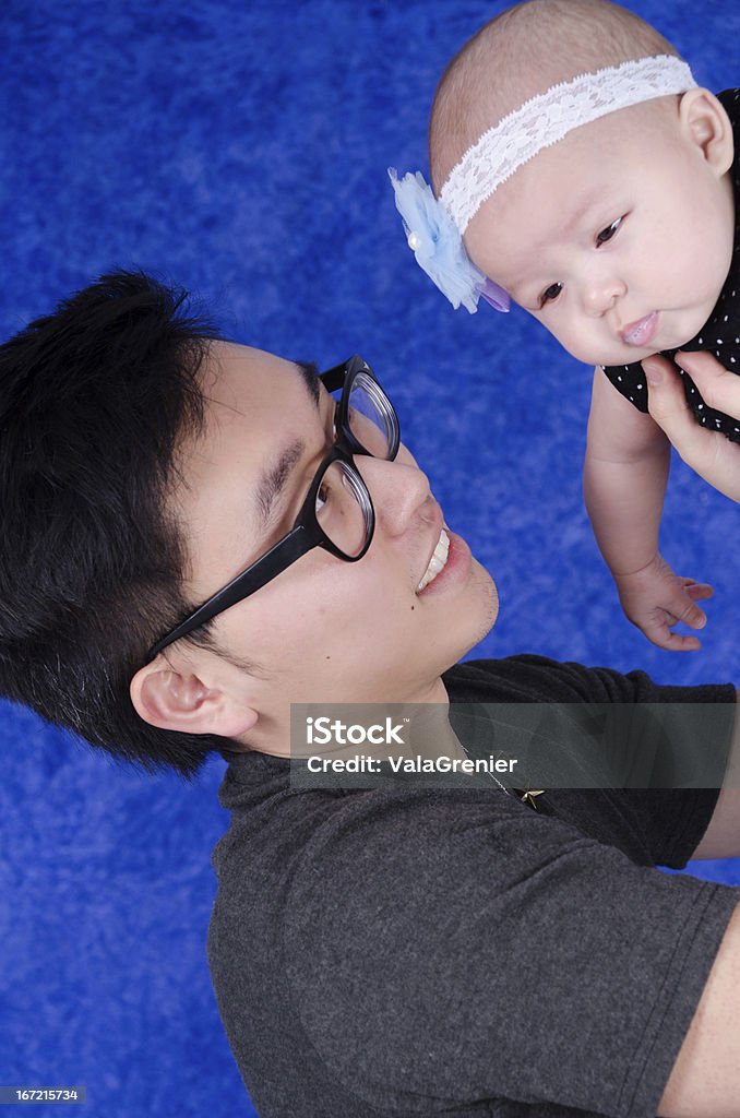 Jeune asiatique souriant père tenant sa fille au-dessus de lui. - Photo de 0-11 mois libre de droits