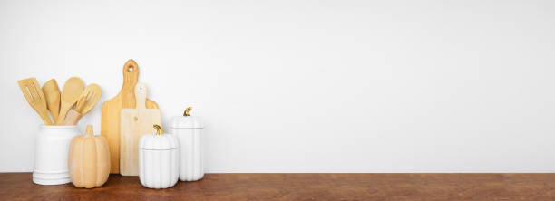 istock Autumn theme kitchenware, utensils and decor on a wood shelf banner background 1672174848