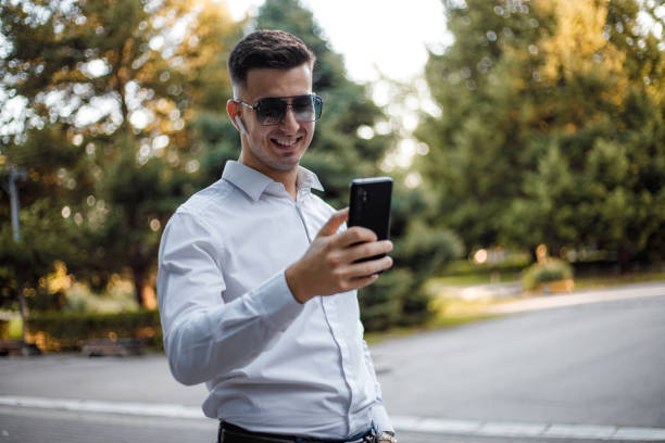 A young manager in a white shirt is typing a message on the phone
