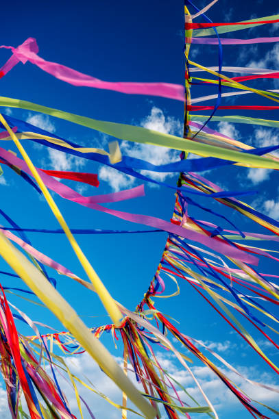 istock Multicolored ribbons or garlands flutter in the wind on a summer sunny day with a blue sky with clouds.The concept of a festive decoration for religious ceremonies. Retreat yoga festival 1672192176