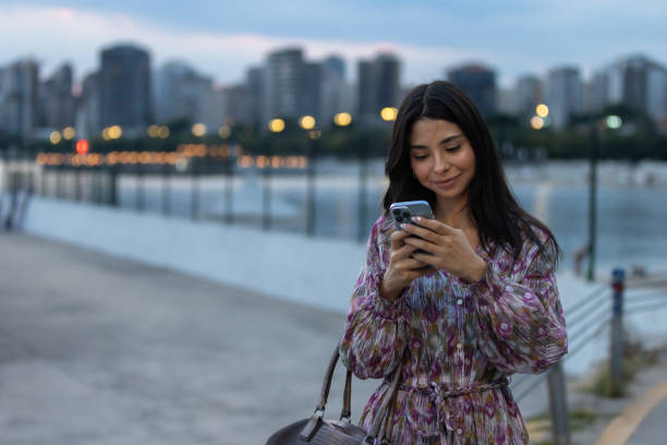 istock Young woman is texting a message on mobile phone on the outside. 1672194926