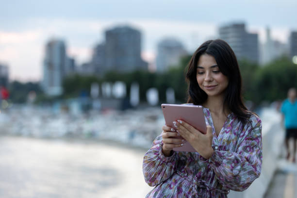 istock Well-dressed young woman is checking mails on portable device. 1672205138