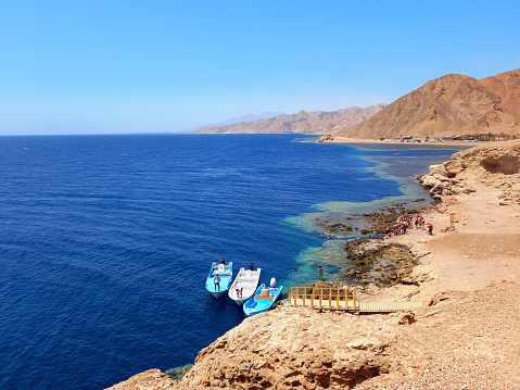 Panoramic view of the Red Sea coast with fishing boat and Desert mountain. Extreme landscapes.