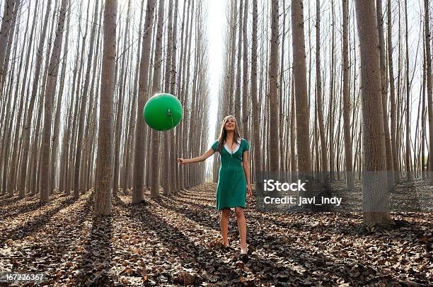 Beautiful Blonde Girl Dressed In Green Walking Into The Forest Stock Photo - Download Image Now